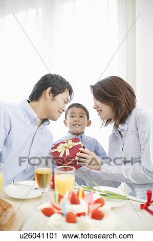 Stock Image - Family celebrating son's birthday at home. Fotosearch