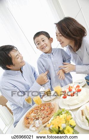 Family celebrating son's birthday at home View Large Photo Image Stock Image - Family celebrating son's birthday at home. Fotosearch