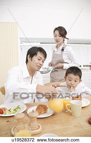 Stock Image - Family eating breakfast. Fotosearch