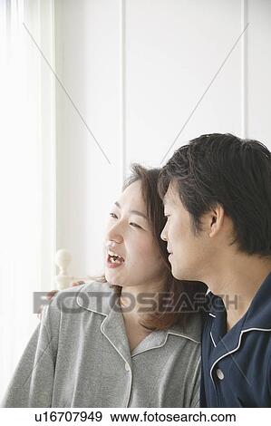 Stock Photo - Mid adult couple sitting in bed. Fotosearch