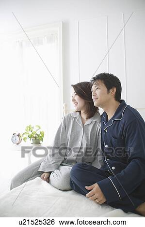 Mid adult couple sitting in bed View Large Photo Image Stock Photograph - Mid adult couple sitting in bed. Fotosearch