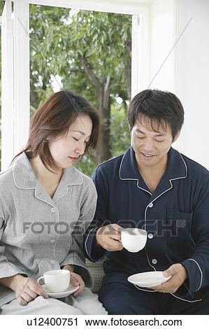 Stock Image - Mid adult holding cup. Fotosearch