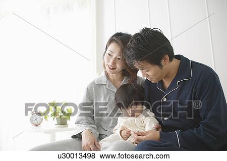 Mother, father and daughter sitting in bed View Large Photo Image Stock Photo - Mother, father and daughter sitting in bed. Fotosearch