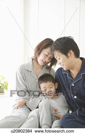 Mother, Father and son sitting in bed View Large Photo Image Picture - Mother, Father and son sitting in bed. Fotosearch