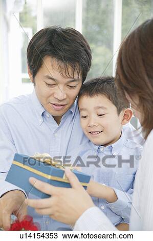 Stock Image - Mother giving present to son. Fotosearch