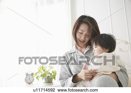 Stock Image - Mother holding baby girl. Fotosearch