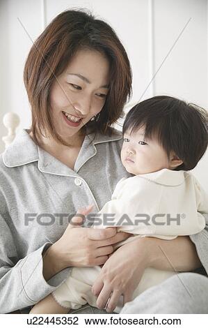 Stock Image - Mother holding baby girl. Fotosearch