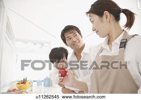 Mother holding tomato in kitchen View Large Photo Image Stock Photography - Mother holding tomato in kitchen. Fotosearch