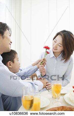 Stock Photograph - Son giving flower to mother. Fotosearch