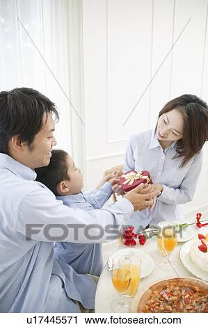 Stock Image - Son giving present to mother. Fotosearch