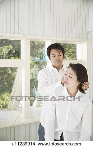 Picture - A mid adult man holding mid adult woman's hair. Fotosearch