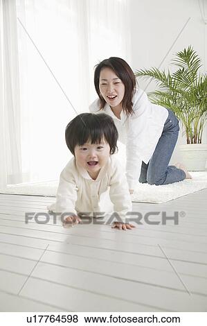 Baby girl crawling and mother following View Large Photo Image Stock Photo - Baby girl crawling and mother following. Fotosearch