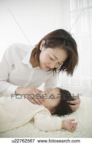 Baby girl sleeping with mother watching View Large Photo Image Stock Photo - Baby girl sleeping with mother watching. Fotosearch