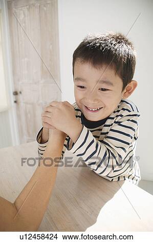 Picture - Boy arm-wrestling with father. Fotosearch