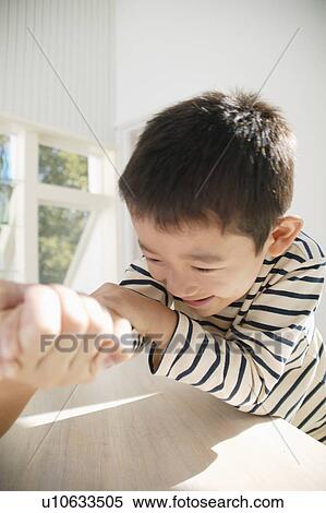 Stock Photography - Boy arm-wrestling with father. Fotosearch
