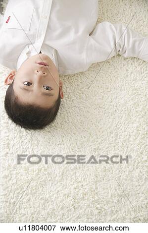 Stock Photo - Boy lying on floor. Fotosearch