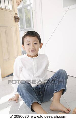 Stock Image - Boy sitting on floor with smile. Fotosearch