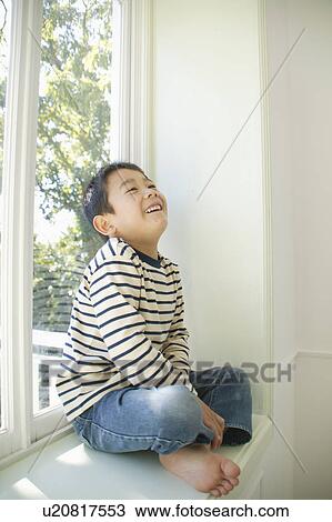 Boy sitting on windowsill View Large Photo Image Stock Image - Boy sitting on windowsill. Fotosearch