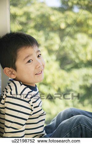 Boy sitting on windowsill View Large Photo Image Stock Image - Boy sitting on windowsill. Fotosearch