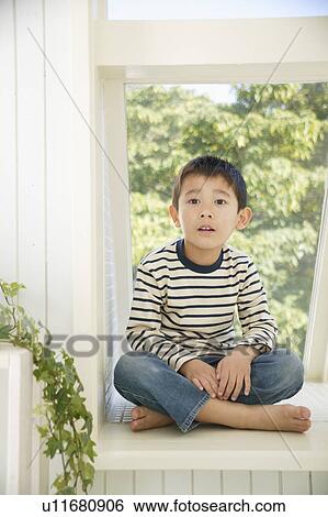 Boy sitting on windowsill View Large Photo Image Stock Photograph - Boy sitting on windowsill. Fotosearch