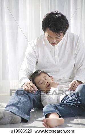 Stock Photo - Boy sleeping on father's lap. Fotosearch