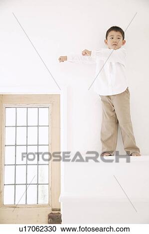 Stock Image - Boy standing on steps. Fotosearch