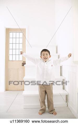 Stock Image - Boy standing with his arms stretched. Fotosearch