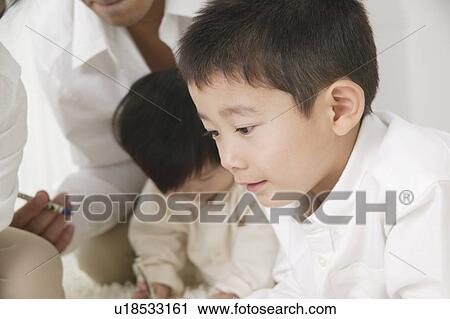 Stock Image - Family playing with crayon, close-up. Fotosearch