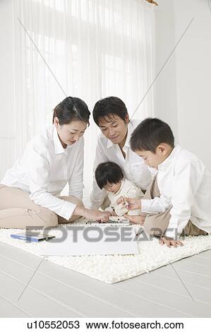 Stock Image - Family playing with crayon. Fotosearch