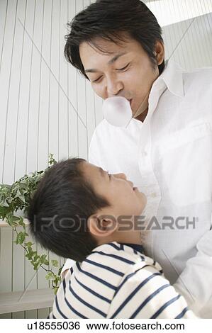 Father blowing chewing gum and son laughing at View Large Photo Image Stock Photograph - Father blowing chewing gum and son laughing at. Fotosearch