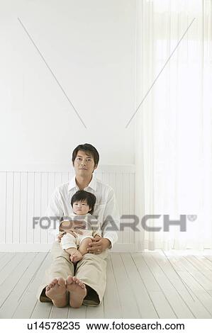 Father sitting with a baby girl holding on lap View Large Photo Image Stock Photography - Father sitting with a baby girl holding on lap. Fotosearch