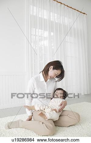 Picture - Mother holding baby girl. Fotosearch