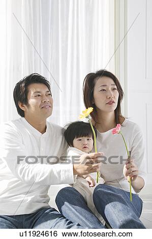 Stock Photograph - Portrait of a family holding flower. Fotosearch
