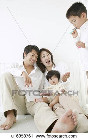 Son playing with bubbles and parents watching with smile. View Large Photo Image Stock Image - Son playing with bubbles and parents watching with smile.. Fotosearch