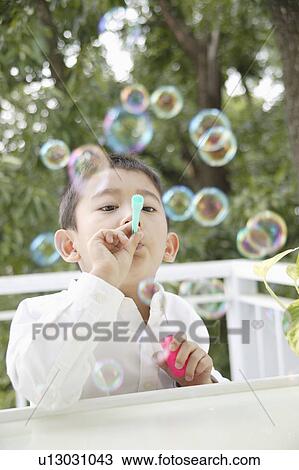 Boy playing with bubbles View Large Photo Image Stock Image - Boy playing with bubbles. Fotosearch