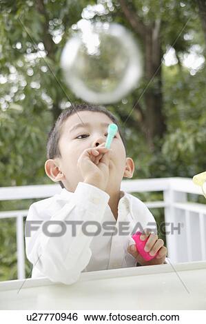 Stock Photograph - Boy playing with bubbles. Fotosearch
