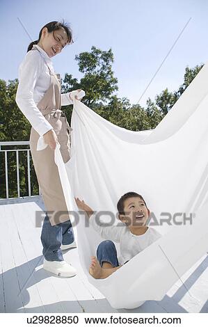 Stock Image - Boy playing with sheet. Fotosearch