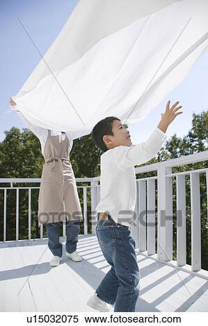 Stock Photography - Boy playing with sheet. Fotosearch