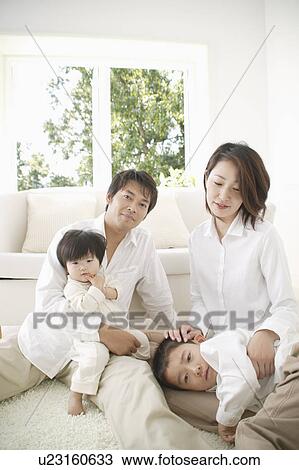 Stock Image - Family relaxing in living room. Fotosearch