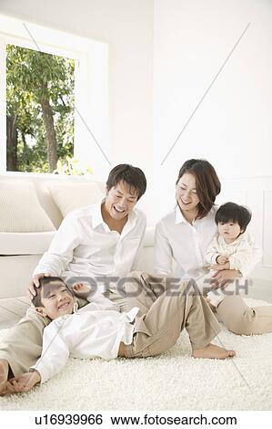 Family relaxing in living room View Large Photo Image Stock Photograph - Family relaxing in living room. Fotosearch