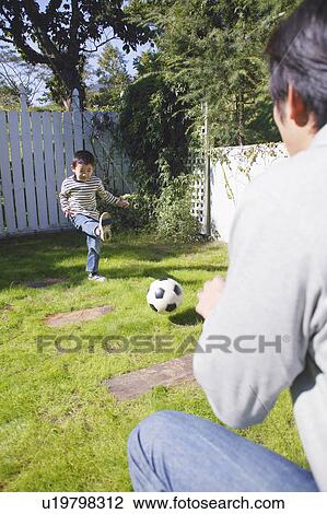 Stock Image - Father and son playing with ball. Fotosearch