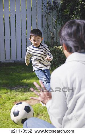 Stock Image - Father and son playing with ball. Fotosearch