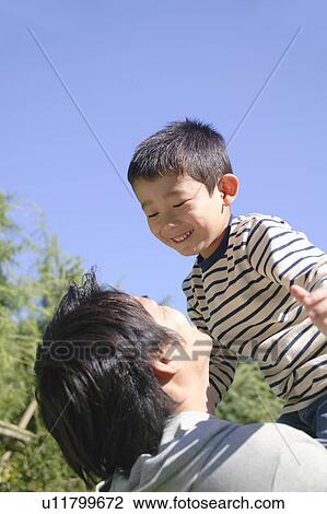 Stock Image - Father lifting son. Fotosearch