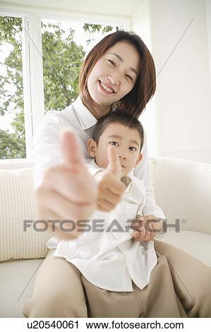 Mother and son looking at camera with thumbs up View Large Photo Image Stock Image - Mother and son looking at camera with thumbs up. Fotosearch