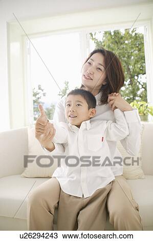 Mother and son sitting on sofa View Large Photo Image Stock Image - Mother and son sitting on sofa. Fotosearch