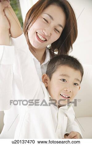 Stock Image - Mother and son smiling with arms outstretched. Fotosearch