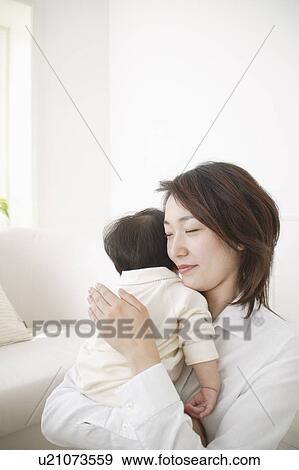 Stock Photo - Mother holding baby girl. Fotosearch