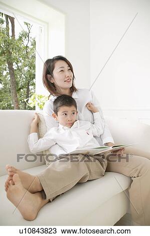 Stock Image - Mother reading a book to son. Fotosearch