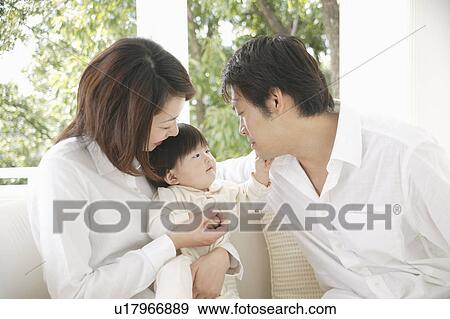 Parents and a baby girl relaxing in living room View Large Photo Image Stock Photo - Parents and a baby girl relaxing in living room. Fotosearch