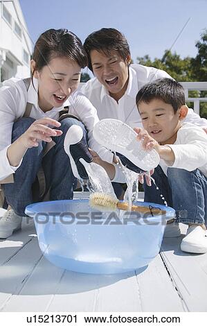 Parents and son washing shoes View Large Photo Image Stock Image - Parents and son washing shoes. Fotosearch